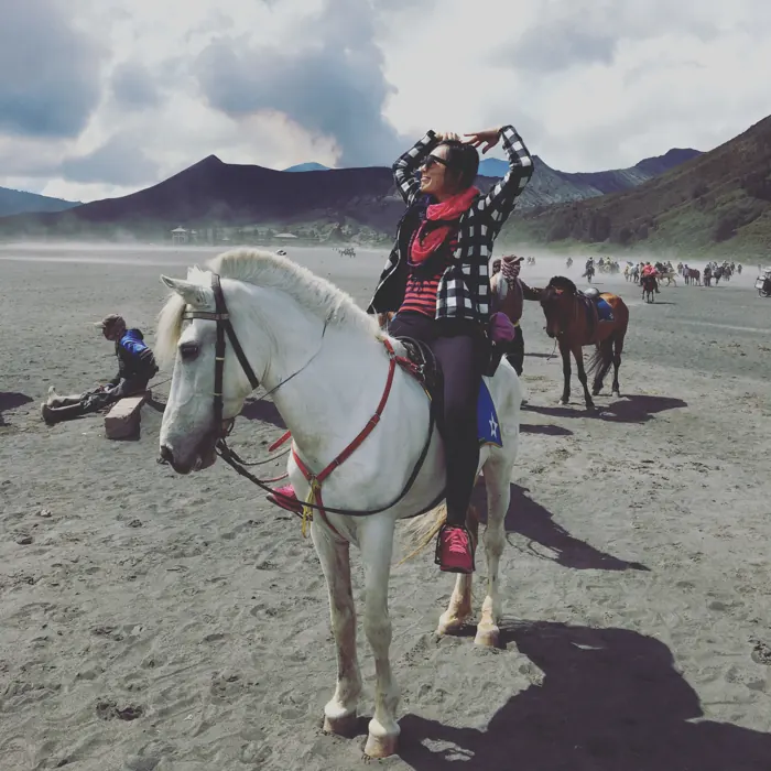 Riding a white horse across the sand